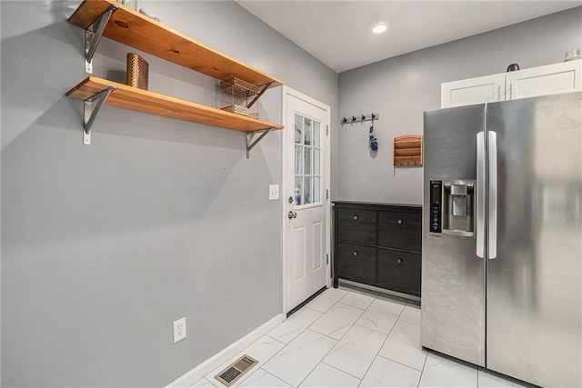 kitchen with visible vents, marble finish floor, open shelves, white cabinets, and stainless steel fridge with ice dispenser