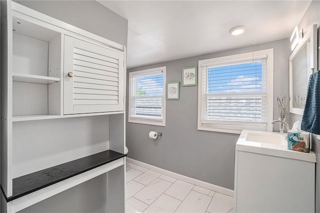 bathroom with vanity, baseboards, and marble finish floor