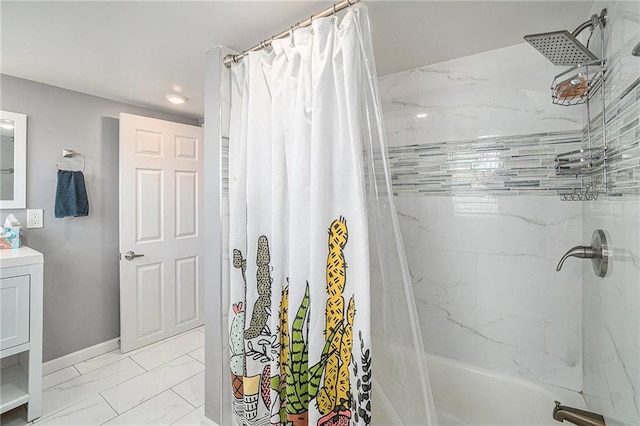 full bathroom featuring vanity, shower / bath combo with shower curtain, baseboards, and marble finish floor