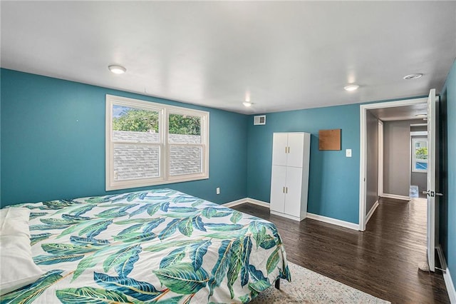 bedroom featuring visible vents, baseboards, and dark wood-style flooring