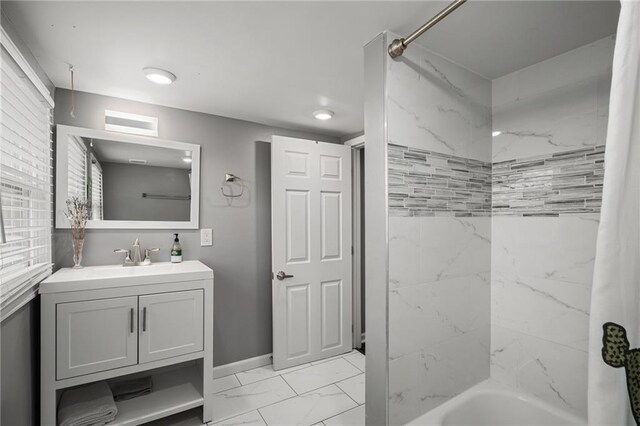 2937 Paseo Blvd, Kansas City, MO 64109 - full bath with marble look tiles, vanity,  shower combination, and baseboards