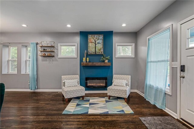 2937 Paseo Blvd, Kansas City, MO 64109 - sitting room with a glass covered fireplace, wood finished floors, baseboards, healthy amount of natural light, and recessed lighting