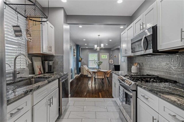2937 Paseo Blvd, Kansas City, MO 64109 - kitchen with stainless steel appliances, light marble finish floors, recessed lighting, backsplash, and white cabinetry