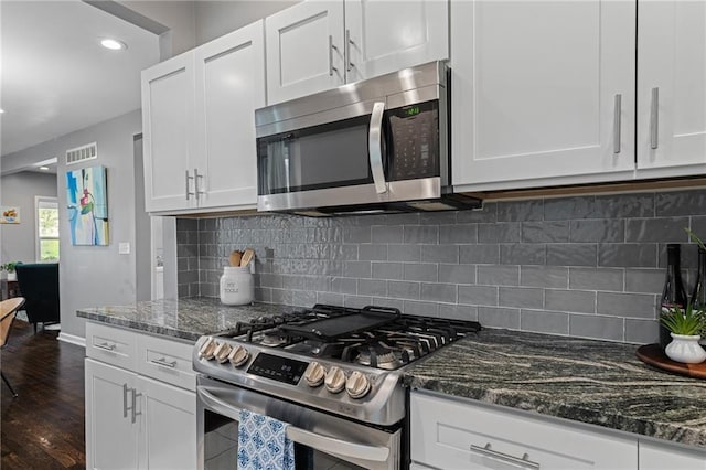2937 Paseo Blvd, Kansas City, MO 64109 - kitchen featuring appliances with stainless steel finishes, white cabinets, dark stone countertops, dark wood finished floors, and recessed lighting