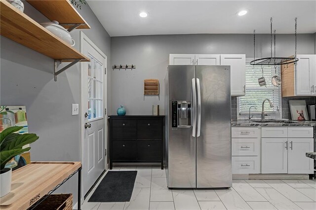 2937 Paseo Blvd, Kansas City, MO 64109 - kitchen with stainless steel fridge with ice dispenser, light marble finish flooring, open shelves, recessed lighting, and white cabinetry
