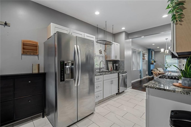 2937 Paseo Blvd, Kansas City, MO 64109 - kitchen featuring appliances with stainless steel finishes, dark stone counters, white cabinetry, a sink, and recessed lighting