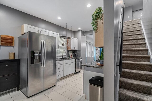 2937 Paseo Blvd, Kansas City, MO 64109 - kitchen with stainless steel appliances, a sink, white cabinets, light marble finish floors, and recessed lighting