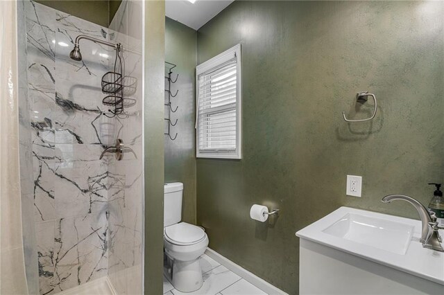 2937 Paseo Blvd, Kansas City, MO 64109 - bathroom featuring toilet, marble look tiles, a marble finish shower, baseboards, and vanity