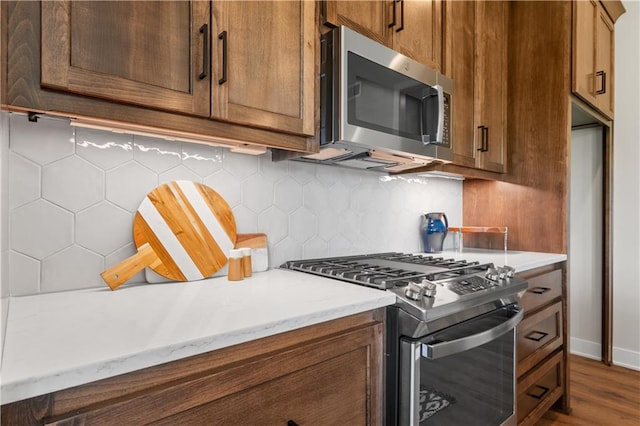 kitchen featuring backsplash, stainless steel appliances, and dark hardwood / wood-style floors