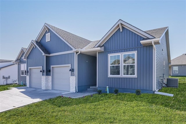 view of front of property featuring cooling unit, a garage, and a front lawn