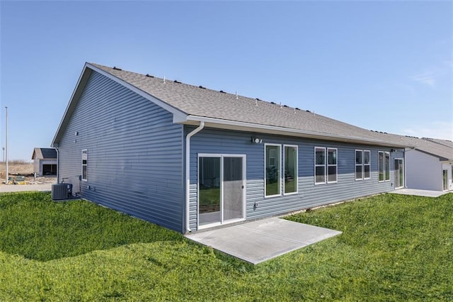 rear view of property featuring a patio, a yard, and central AC