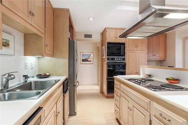 kitchen featuring wall chimney exhaust hood, light countertops, visible vents, a sink, and black appliances