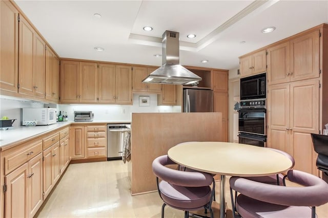 kitchen with light brown cabinets, recessed lighting, island range hood, black appliances, and a tray ceiling