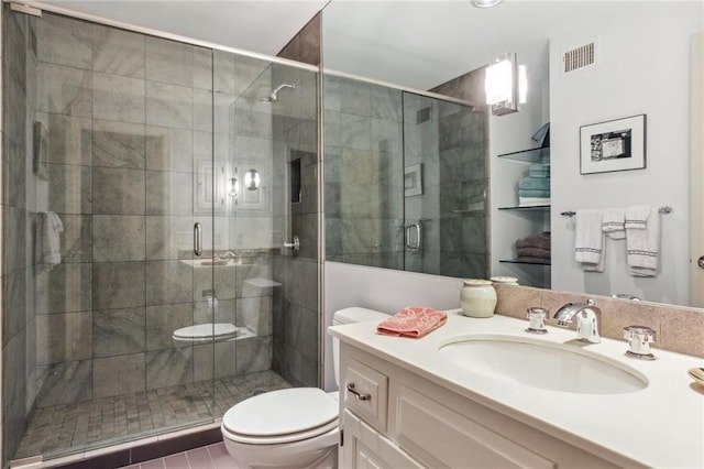 bathroom with toilet, a stall shower, visible vents, and vanity