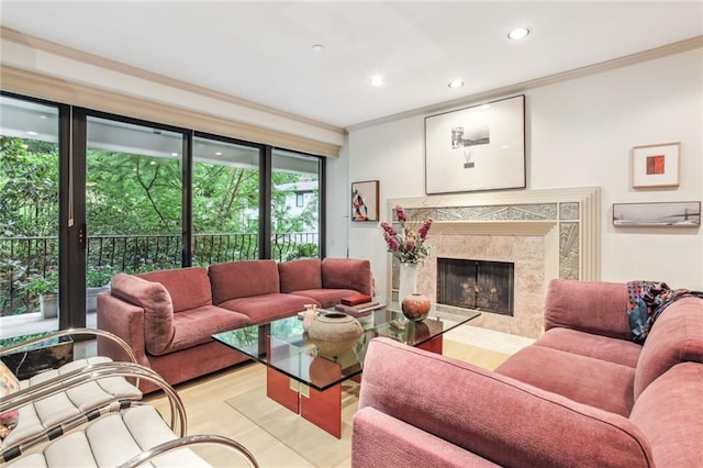 living room featuring light hardwood / wood-style flooring, crown molding, and a high end fireplace