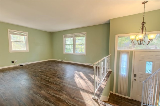 entryway with dark hardwood / wood-style flooring, a healthy amount of sunlight, and a notable chandelier