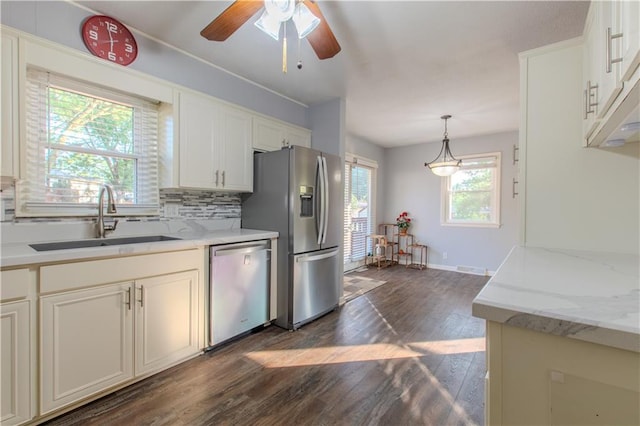 kitchen featuring stainless steel appliances, dark hardwood / wood-style flooring, sink, ceiling fan, and hanging light fixtures