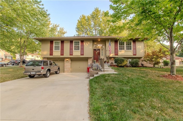 raised ranch featuring a garage and a front lawn