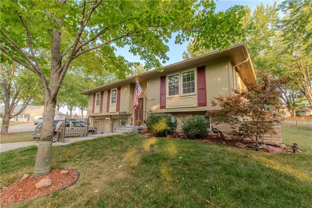 raised ranch featuring a front yard and a deck