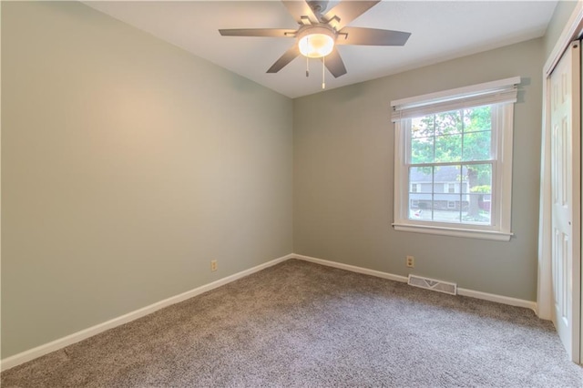 carpeted spare room featuring ceiling fan