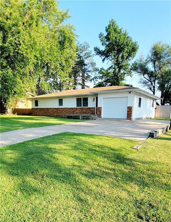 single story home featuring a front lawn and a garage