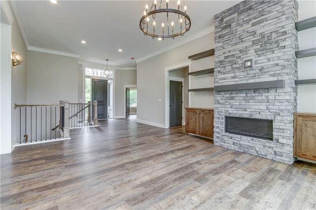 unfurnished living room featuring hardwood / wood-style floors, a fireplace, an inviting chandelier, and ornamental molding