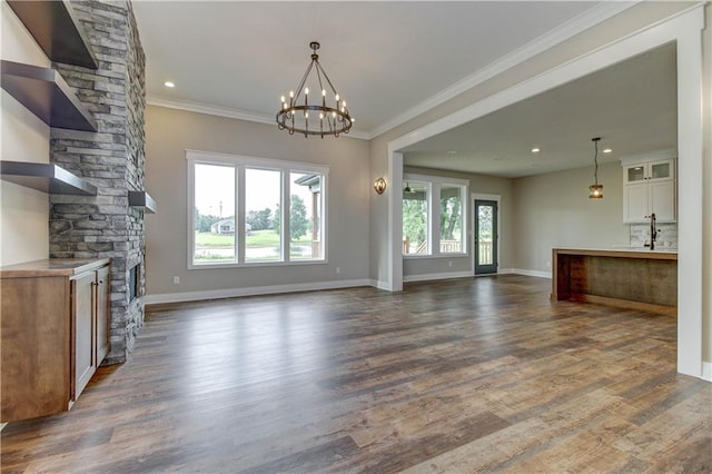 unfurnished living room with a healthy amount of sunlight, ornamental molding, a stone fireplace, and dark hardwood / wood-style flooring