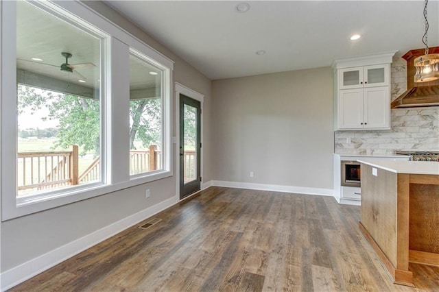 kitchen with hardwood / wood-style floors, white cabinetry, backsplash, decorative light fixtures, and ceiling fan