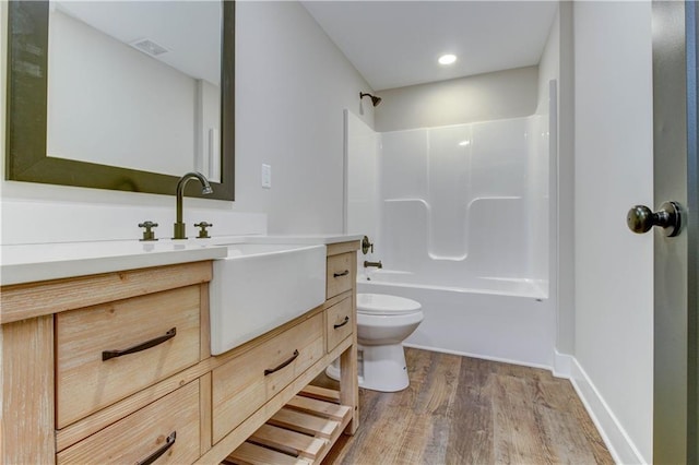 full bathroom with vanity, toilet, hardwood / wood-style flooring, and shower / bathtub combination