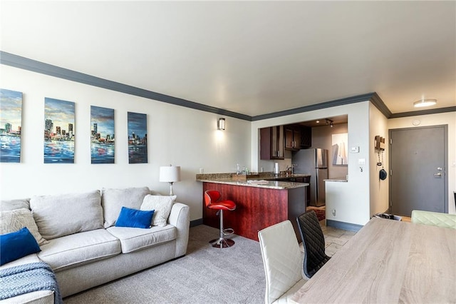 700 E 8th St Unit 11P, Kansas City, MO 64106 - living room featuring ornamental molding, baseboards, and bar area