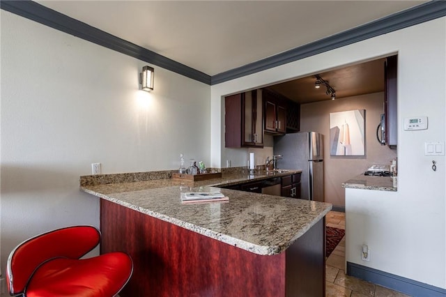 700 E 8th St Unit 11P, Kansas City, MO 64106 - kitchen with baseboards, a peninsula, crown molding, freestanding refrigerator, and rail lighting