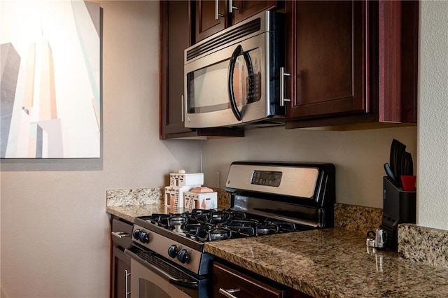 700 E 8th St Unit 11P, Kansas City, MO 64106 - kitchen with appliances with stainless steel finishes, dark stone countertops, and dark brown cabinetry
