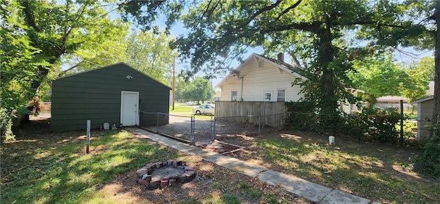 view of yard featuring a storage shed, fence, and an outdoor structure