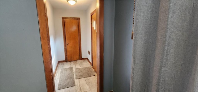 hall with baseboards and light wood finished floors