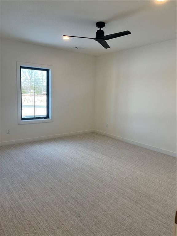 unfurnished room featuring light carpet, ceiling fan, and baseboards