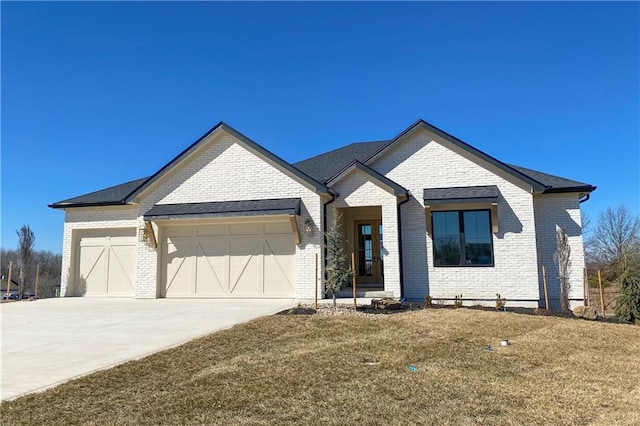 view of front of home featuring a garage, brick siding, concrete driveway, and a front yard