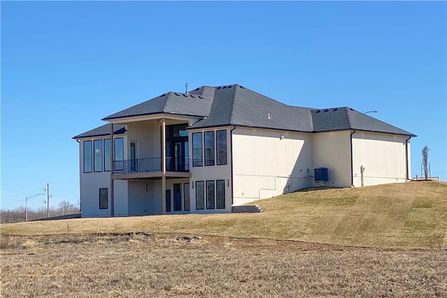 back of property with a yard and central AC