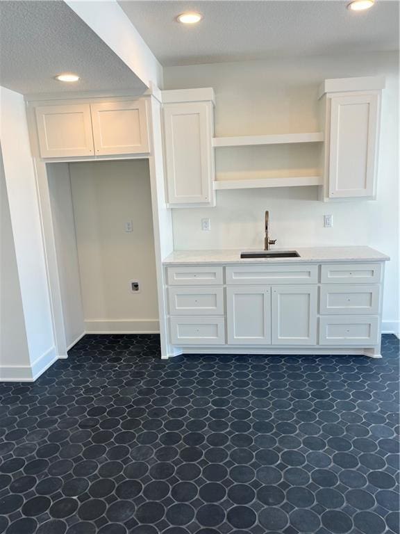 kitchen featuring white cabinets, recessed lighting, and a sink