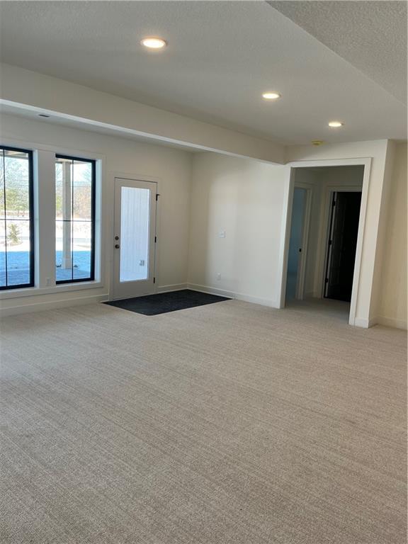 unfurnished room featuring recessed lighting, light colored carpet, and baseboards