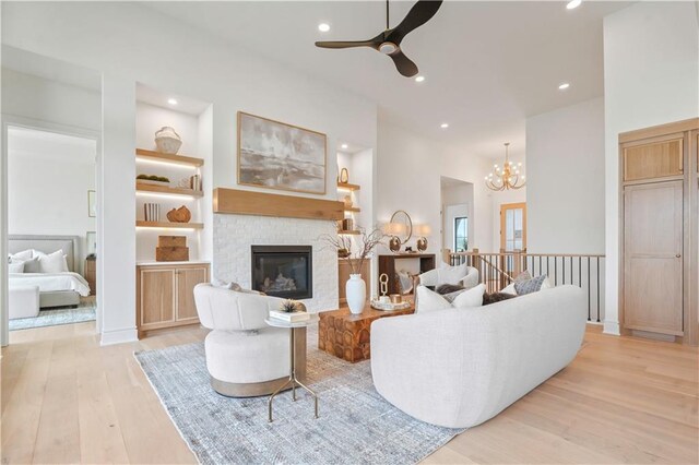 1816 NE Lashbrook Cir, Lees Summit, MO 64086 - living area featuring ceiling fan with notable chandelier, a glass covered fireplace, light wood finished floors, and recessed lighting