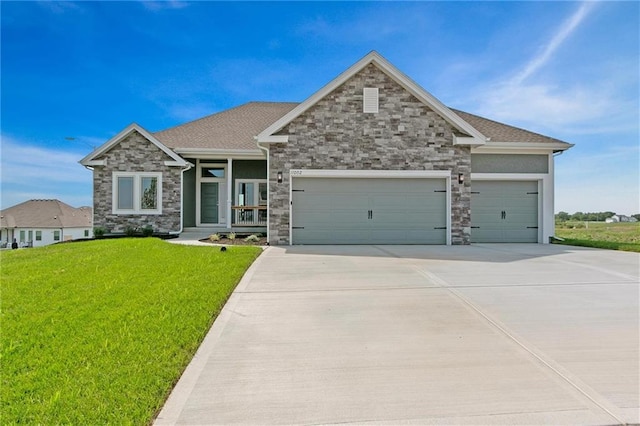 craftsman-style house featuring roof with shingles, an attached garage, stone siding, driveway, and a front lawn