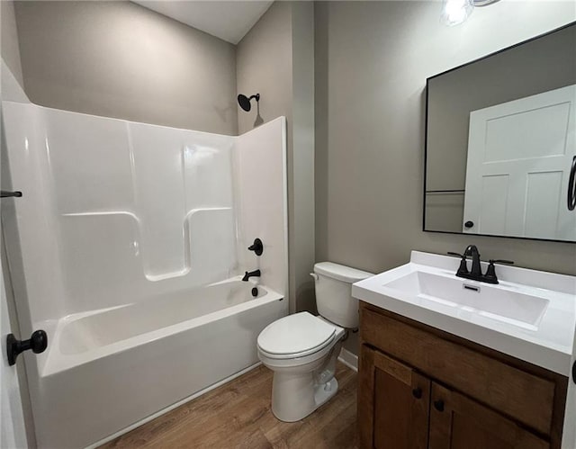 full bathroom with shower / bathing tub combination, vanity, hardwood / wood-style flooring, and toilet