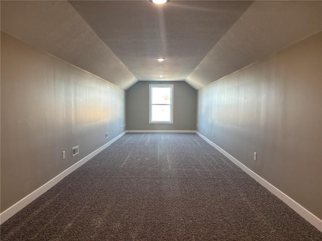 bonus room with carpet, a textured ceiling, and vaulted ceiling