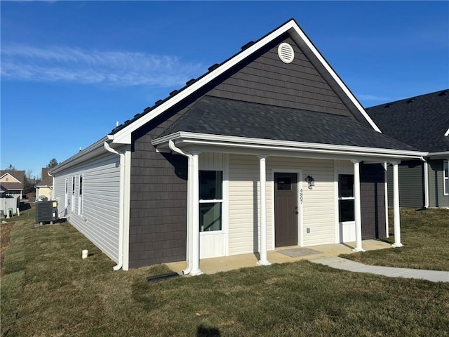 rear view of house featuring a yard and central air condition unit