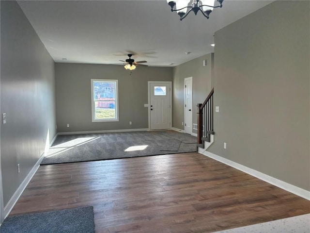 entryway with dark hardwood / wood-style flooring and ceiling fan with notable chandelier