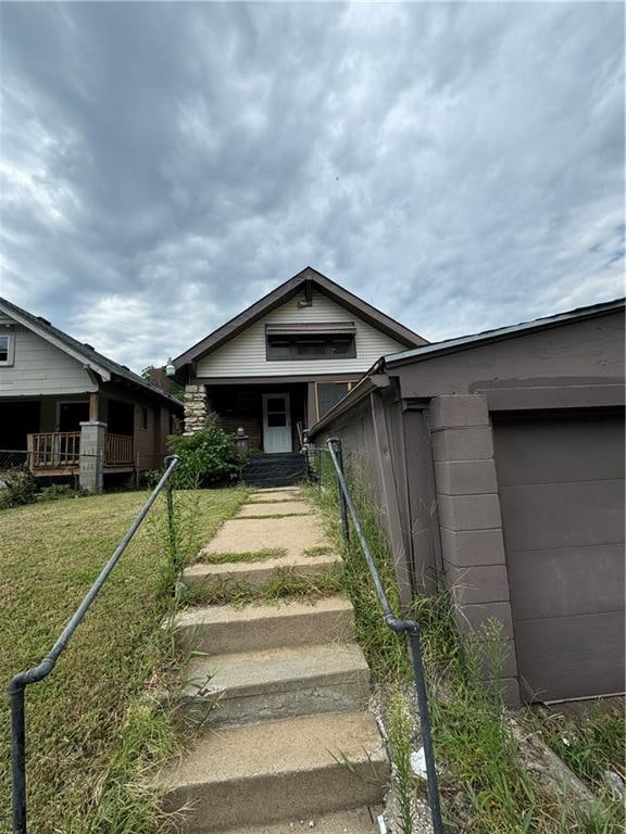 view of exterior entry with a garage and a lawn