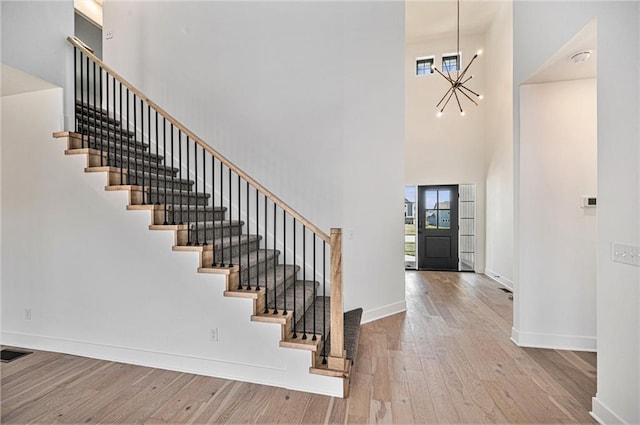 foyer featuring a high ceiling, light hardwood / wood-style flooring, and an inviting chandelier