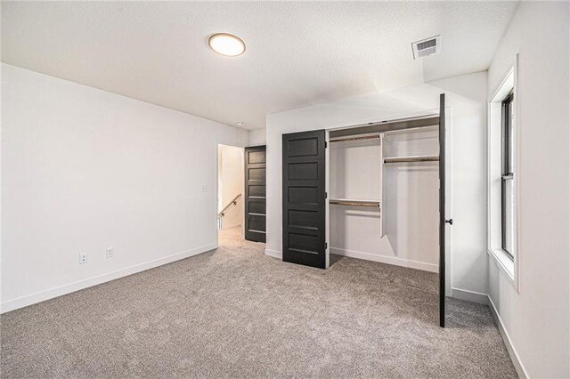 unfurnished bedroom with a closet and light carpet