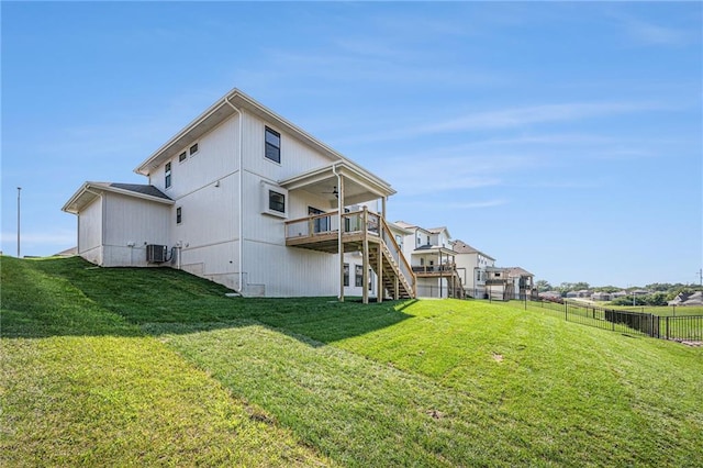 back of house featuring a deck, central AC unit, and a lawn