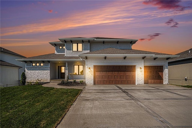 prairie-style house with a garage and a lawn